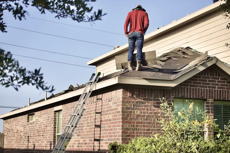 Professional roofer working on a residential roof in University West
